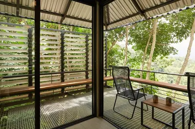 a screened in porch with a chair and a table at Amazing Mountain View Lodge with Pool in Kuala Kubu Baharu