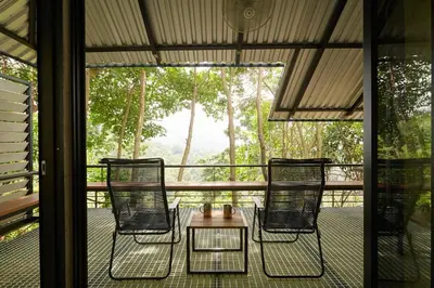 a screened in porch with three chairs and a table at Amazing Mountain View Lodge with Pool in Kuala Kubu Baharu