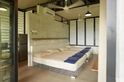 a bedroom with a large bed with blue pillows at Amazing Mountain View Lodge with Pool in Kuala Kubu Baharu