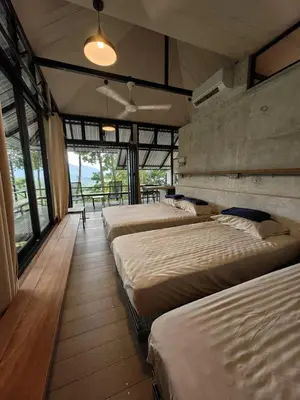a row of beds in a room with windows at Amazing Mountain View Lodge with Pool in Kuala Kubu Baharu
