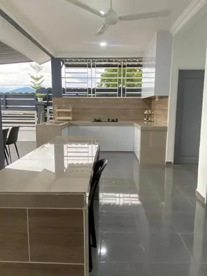 a kitchen with a table and chairs in a room at D'Savanna Homestay Gerik in Gua Sai
