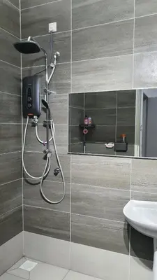 a shower in a bathroom with a sink at D'Savanna Homestay Gerik in Gua Sai