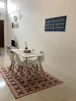 a dining room table and chairs on a rug at D' Ara SZ Homestay in Kubang Semang
