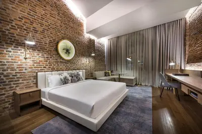 a bedroom with a bed and a brick wall at Loke Thye Kee Heritage Suite Hotel's in Gua Sai