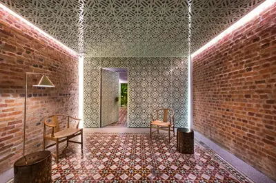 a room with two chairs and a brick wall at Loke Thye Kee Heritage Suite Hotel's in Gua Sai