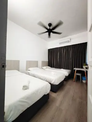a bedroom with two beds and a ceiling fan at I-homey Residence 1 in Gua Sai