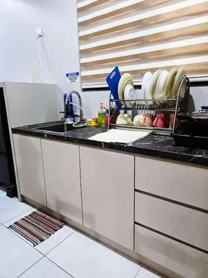 a kitchen counter with a sink and a dish rack with dishes at High Floor sea view 12 pax 3BR luxury suites b29 in Jelutong