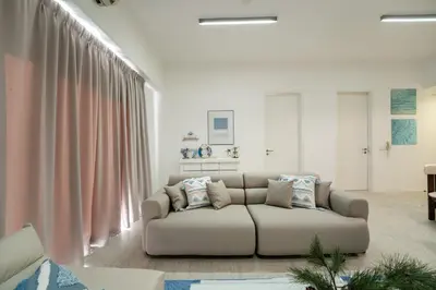 a living room with a couch and a pink curtain at By The Sea Haven 2BR 6pax in Batu Ferringhi