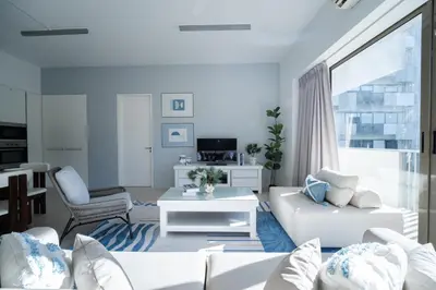 a living room with white furniture and a large window at By The Sea Haven 2BR 6pax in Batu Ferringhi