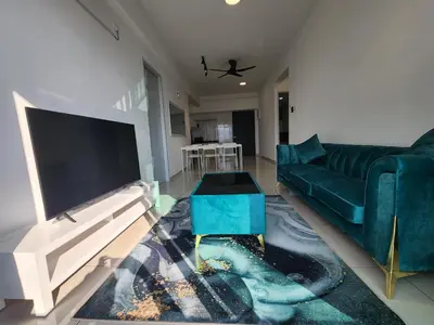 a living room with a green couch and a tv at Praicon Tower Hotel Large Suite 3BR - Butterworth in Butterworth