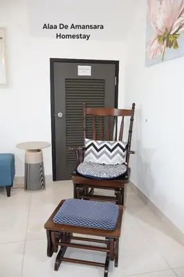 a rocking chair with a pillow on it in a room at Alaa De Amansara Homestay in Kepala Batas