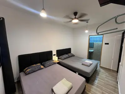 a room with two beds and a ceiling fan at Menglembu Ipoh Homestay M21 Smart TV & WiFi ready in Ipoh