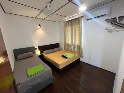 a small room with two beds and a couch at Menglembu Ipoh Homestay M21 Smart TV & WiFi ready in Ipoh