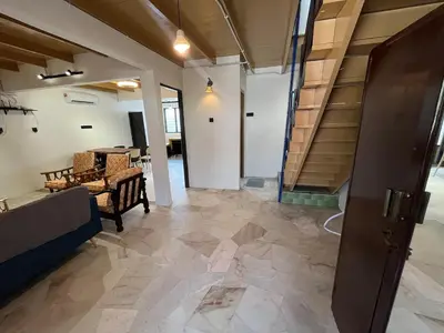 a hallway with a staircase and a living room at Menglembu Ipoh Homestay M21 Smart TV & WiFi ready in Ipoh