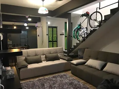 a living room with a couch and a bike on the wall at Ipoh Menglembu M35 Smart TV & Wifi ready in Ipoh