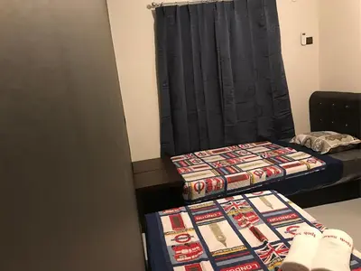 two beds in a room with a black curtain at Ipoh Menglembu M35 Smart TV & Wifi ready in Ipoh