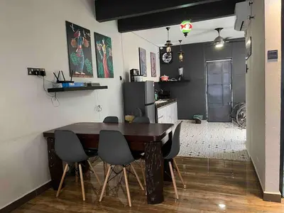 a dining room with a wooden table and chairs at Ipoh Menglembu M35 Smart TV & Wifi ready in Ipoh