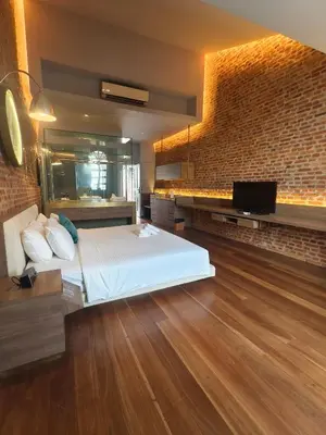 a bedroom with a bed and a brick wall at Loke Thye Kee Heritage Hotel in George Town