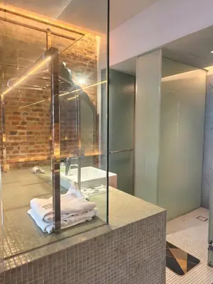 a bathroom with a glass shower and a sink at Loke Thye Kee Heritage Hotel in George Town