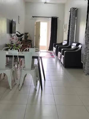 a living room with a table and chairs and a couch at Homestay Rumah Iman in Kamunting