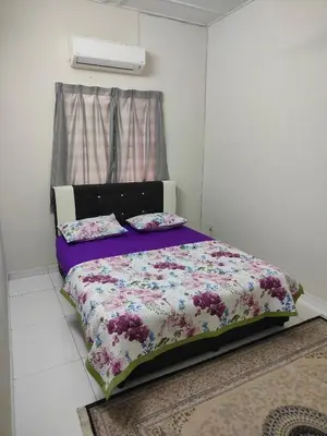 a bedroom with a bed with a purple comforter at Margosa Homestay in Ipoh