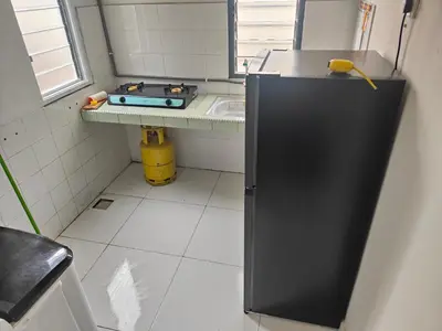 a small kitchen with a black refrigerator and a sink at Margosa Homestay in Ipoh