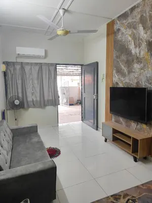 a living room with a couch and a flat screen tv at Margosa Homestay in Ipoh