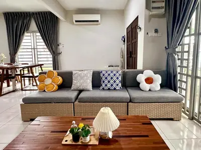a living room with a couch and a table at Charming 4BR Family House Quite Area & Cozy in Simpang Ampat