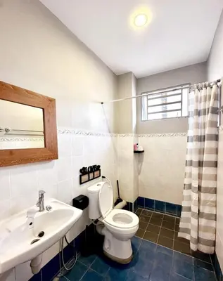 a bathroom with a toilet and a sink at Charming 4BR Family House Quite Area & Cozy in Simpang Ampat