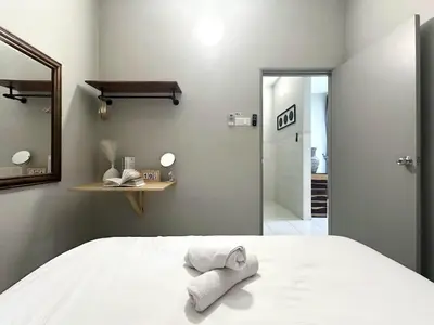 a bedroom with a bed with two towels on it at Charming 4BR Family House Quite Area & Cozy in Simpang Ampat