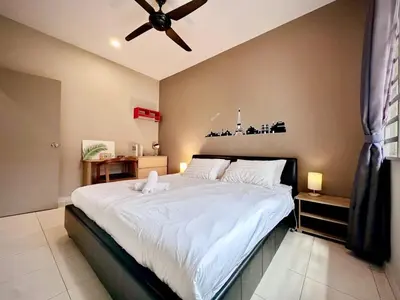 a bedroom with a large bed with a ceiling fan at Charming 4BR Family House Quite Area & Cozy in Simpang Ampat