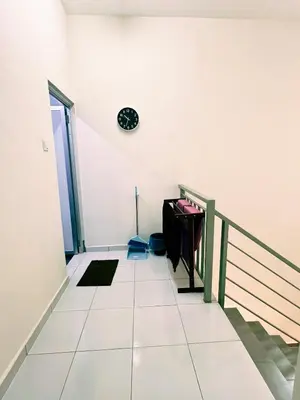 a staircase in a house with a clock on the wall at Homestay Sungai Petani 3 Bedroom in Taman Mutiara Bandar Puteri Jaya by D'Aleena Homes in Sungai Petani