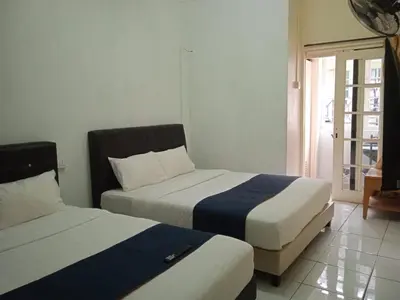 two beds in a room with a window at Rest N Go CH in Tanah Rata