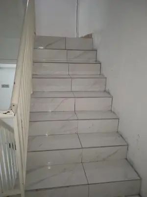 a stairway with white marble steps in a room at Rest N Go CH in Tanah Rata