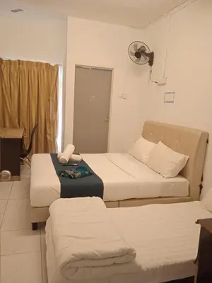 a hotel room with two beds and a fan at Rest N Go CH in Tanah Rata