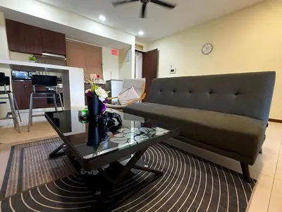 a living room with a couch and a table at Landmark Seaview Cozy Family Suite with Balcony 6 Pax in Tanjong Tokong