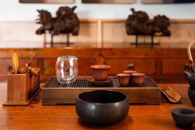 a wooden table with bowls and cups and a glass at Cheong Fatt Tze - The Qing Suites in George Town