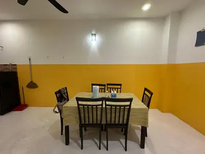 a dining room with a table and chairs at Nady Salam Homestay in Seri Iskandar