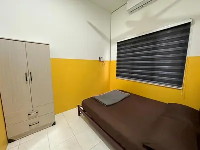 a small bedroom with a bed and a window at Nady Salam Homestay in Seri Iskandar