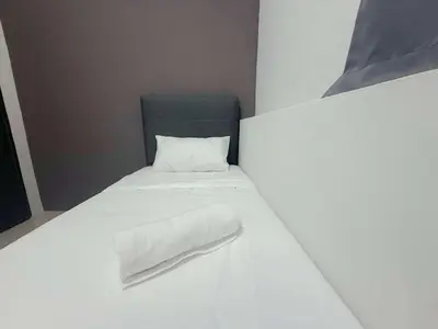 a small white bed with a white blanket on it at Gather inn in George Town