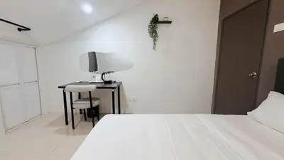 a bedroom with a bed and a desk with a lamp at Gather inn in George Town