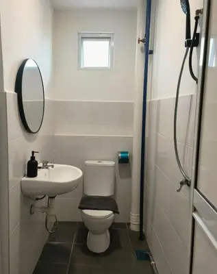 a bathroom with a toilet and a sink and a mirror at Gather inn in George Town