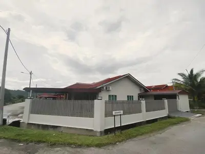 a white house with a fence in front of it at Cozy Corner House, Bandar Utama in Gua Musang