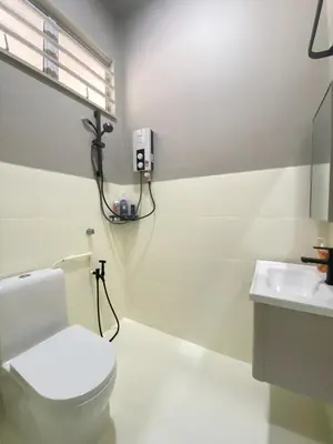 a white bathroom with a toilet and a sink at Cozy Corner House, Bandar Utama in Gua Musang