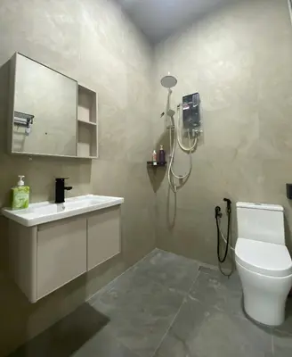 a bathroom with a toilet and a sink and a mirror at Cozy Corner House, Bandar Utama in Gua Musang