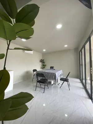 a dining room with a table and chairs and a plant at Cozy Corner House, Bandar Utama in Gua Musang