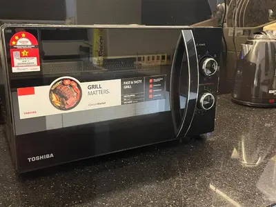 a black microwave oven sitting on top of a counter at Oasis Condominium Ipoh in Ipoh