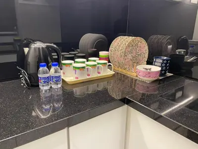 a kitchen counter with bottles of water and a sink at Oasis Condominium Ipoh in Ipoh