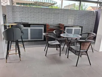 a patio with tables and chairs and a brick wall at Lavender Splash Homestay in Ipoh