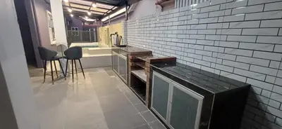 a kitchen with a counter and chairs in a room at Lavender Splash Homestay in Ipoh